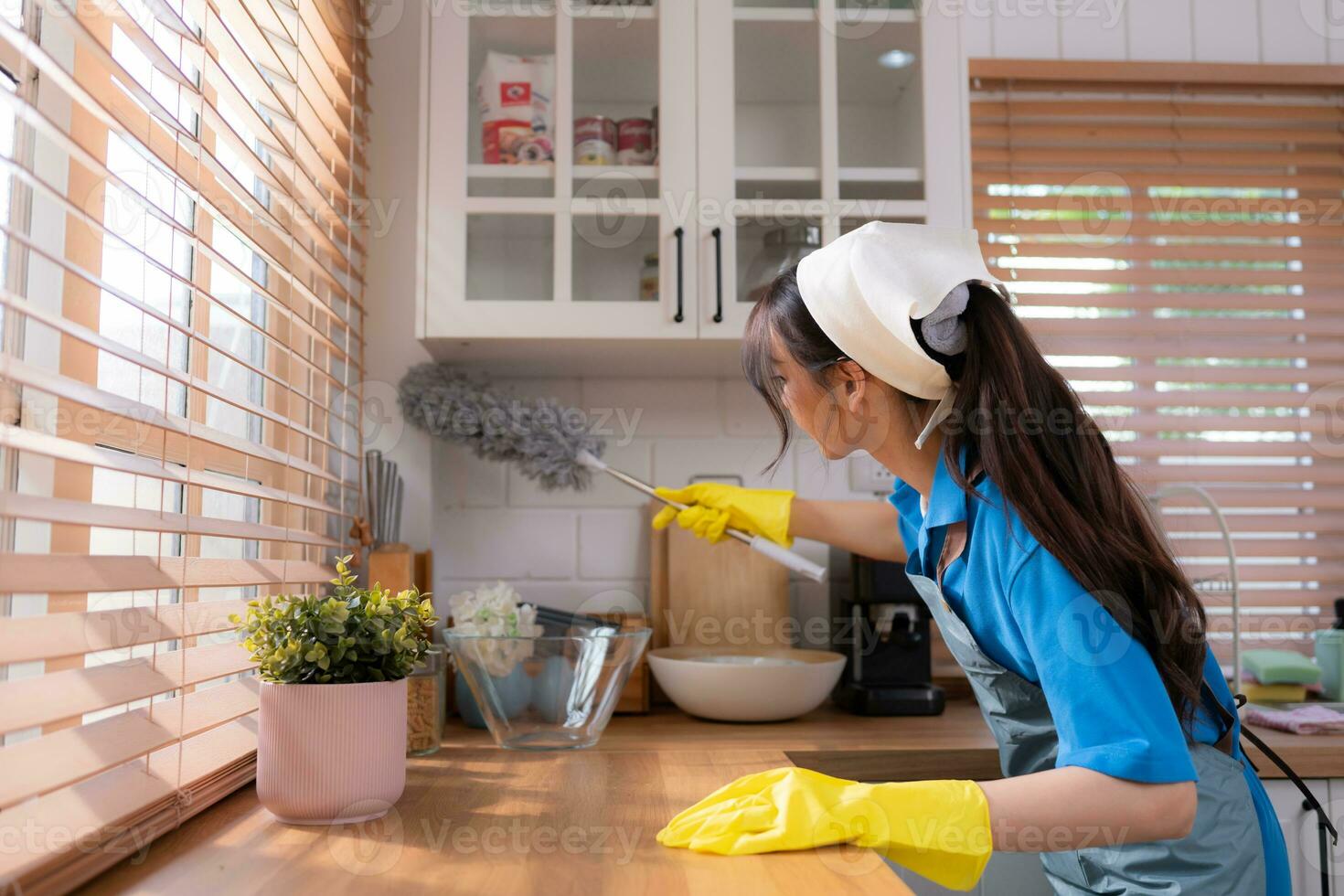 Asian young woman cleaning window in the kitchen. housework concept photo