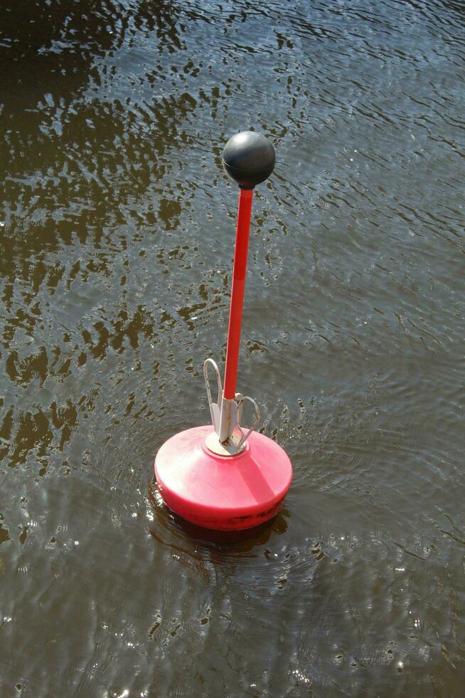 A red buoy floats on the surface of the river photo