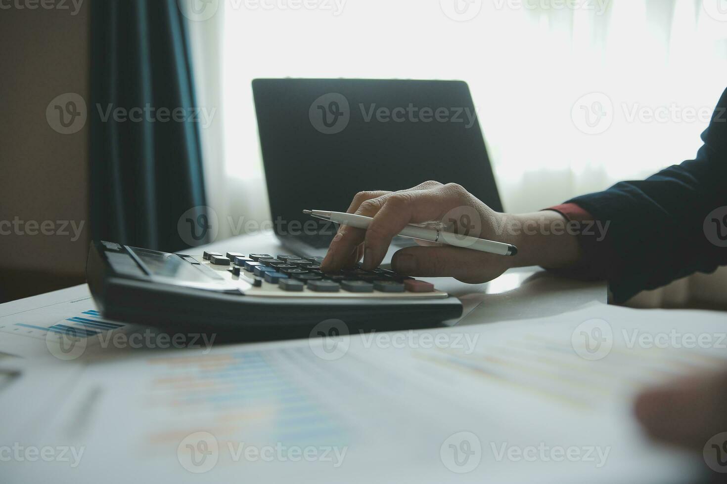 Unrecognizable businessman using calculator photo
