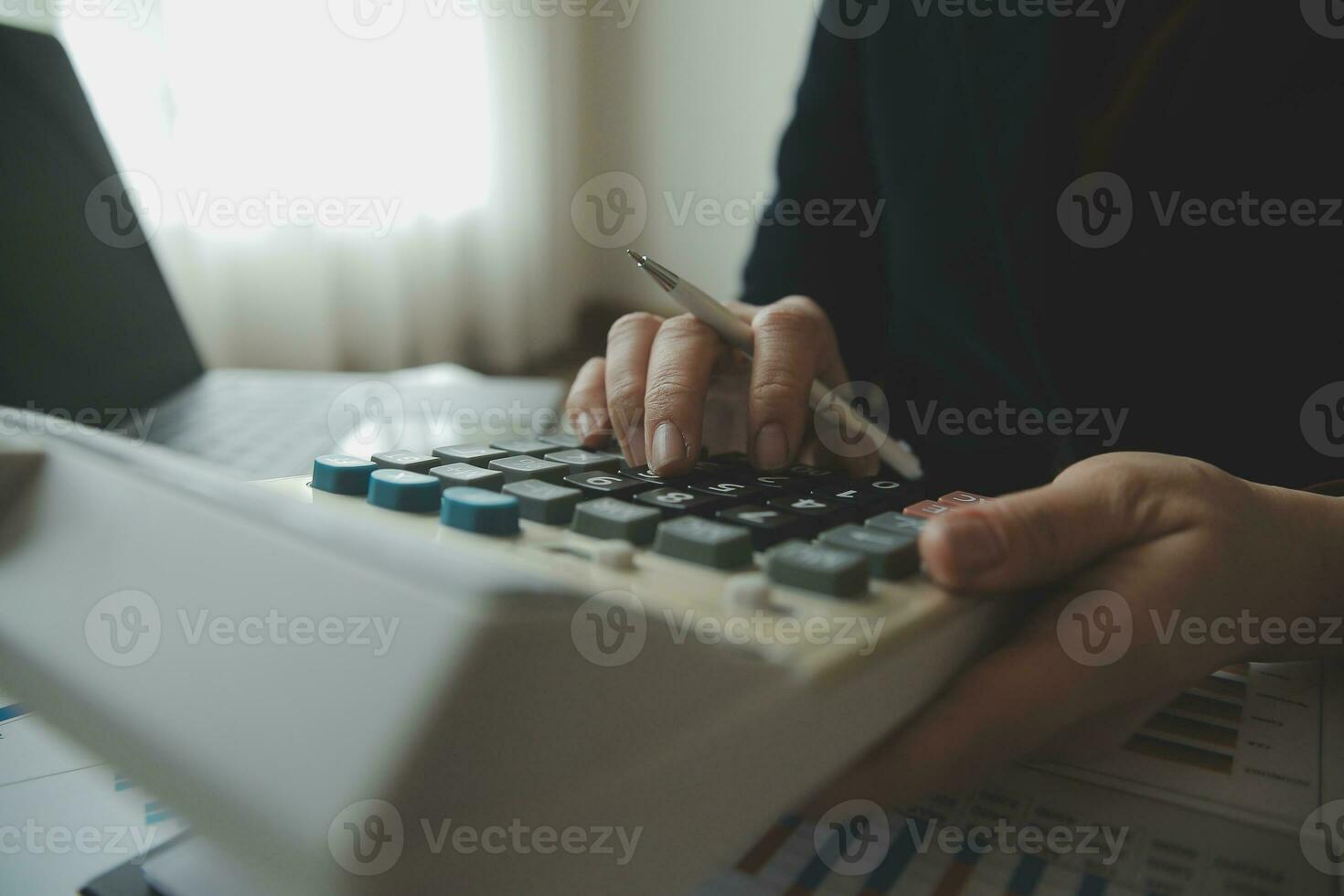 Unrecognizable businessman using calculator photo