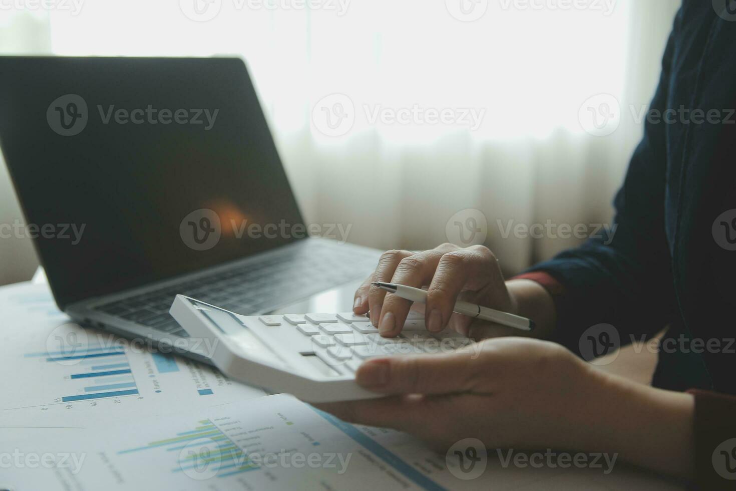 Unrecognizable businessman using calculator photo