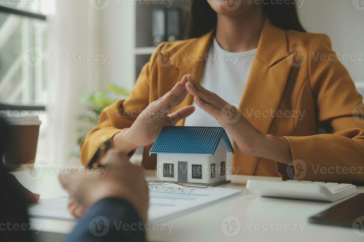Real estate brokerage agent Deliver a sample of a model house to the customer, mortgage loan agreement Making lease and buy and sell house And contract home insurance mortgage loan concept photo