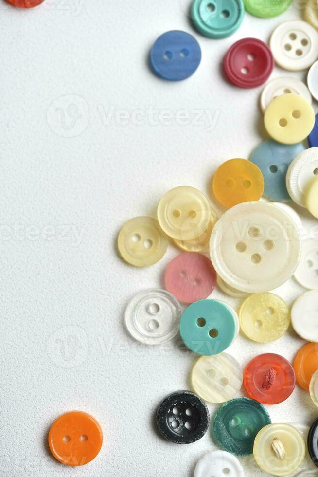 Multicolored buttons on a white background. Round buttons from clothes. photo