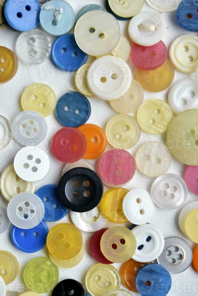 Multicolored buttons on a white background. Round buttons from clothes. photo