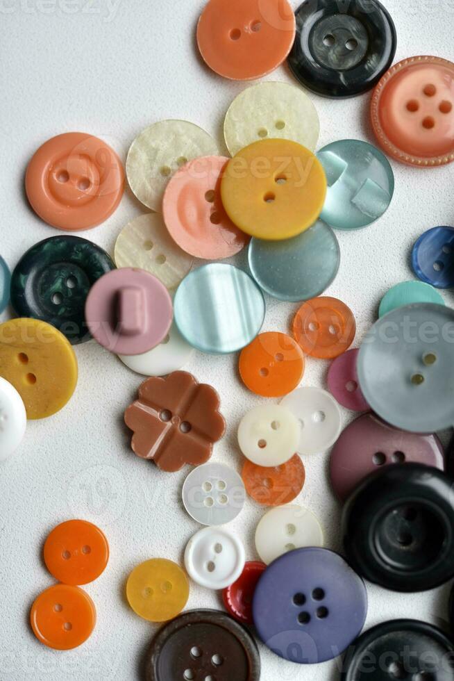 Multicolored buttons on a white background. Round buttons from clothes. photo