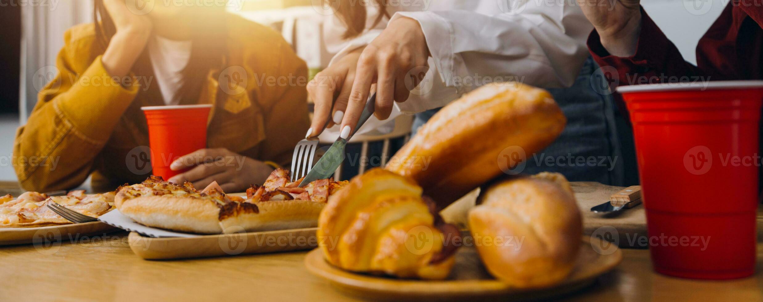 Group of young friends eating pizza at home and having fun photo