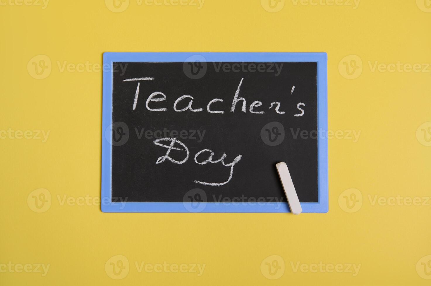 Flat lay of a blackboard with inscription Teachers Day on a yellow background with space for text photo