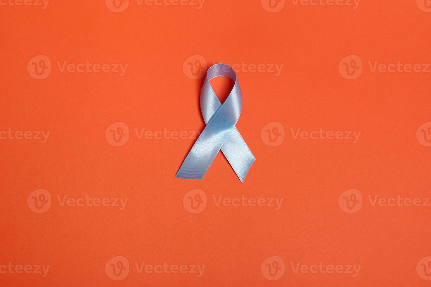 World diabetes day awareness concept. Flat lay of a blue satin ribbon, symbolic bow color raising awareness in diabetes day on orange colored background with copy space for ad, 14 November. photo