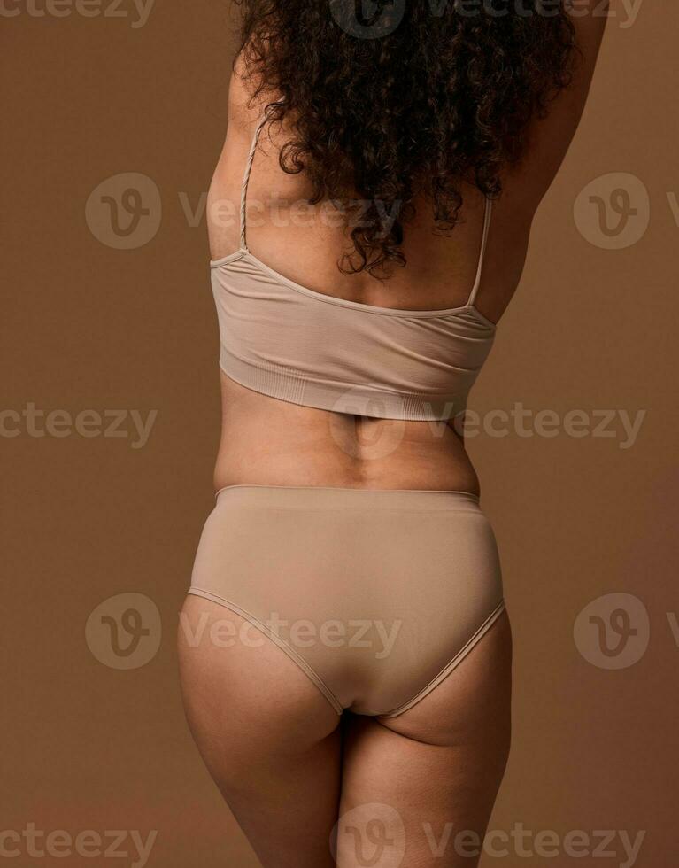 posterior ver de un irreconocible mujer en beige ropa interior con piel problemas y exceso de peso. dermatología, cuerpo positividad, amor aceptación concepto. Copiar espacio para anuncios foto