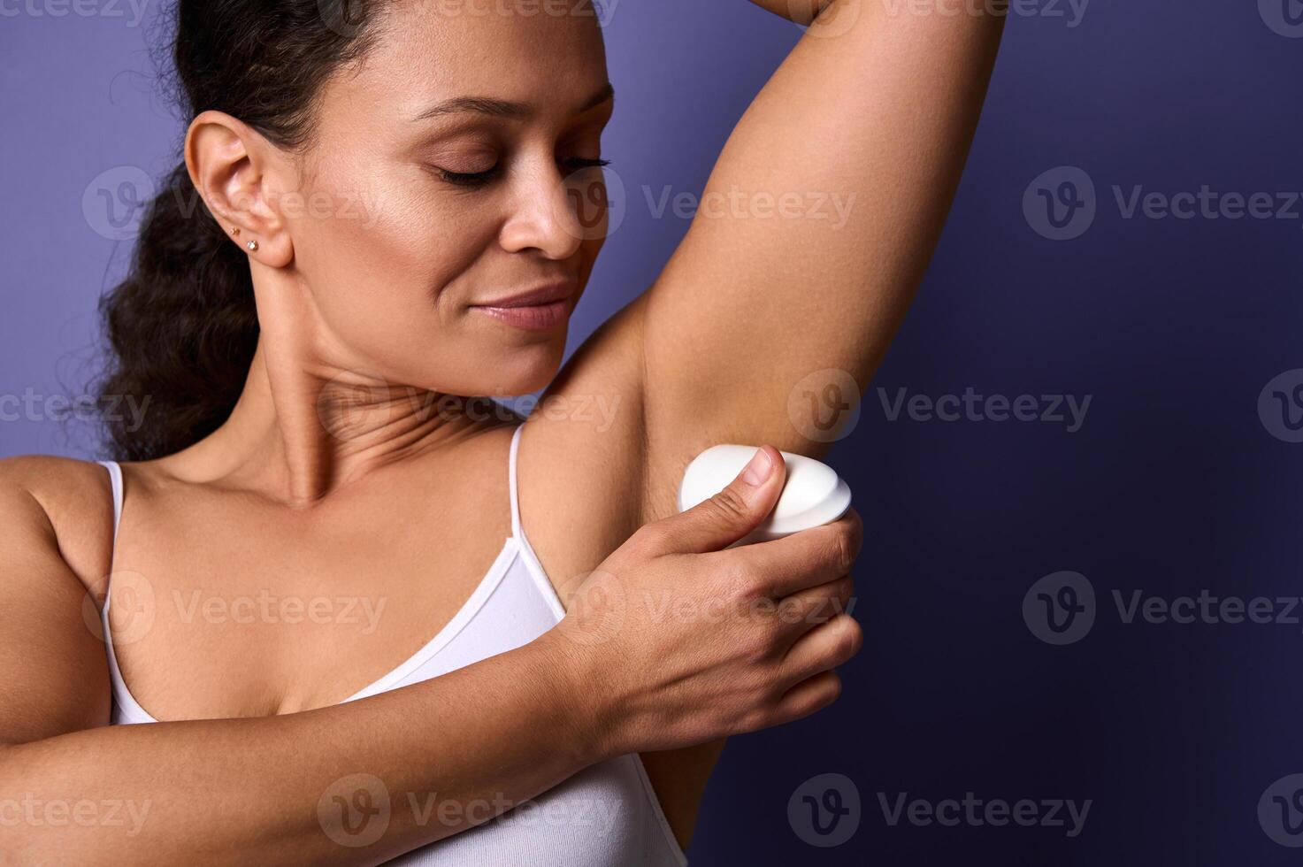 Closeup of a beautiful woman applying rollon antiperspirant underarm. Protective sweating