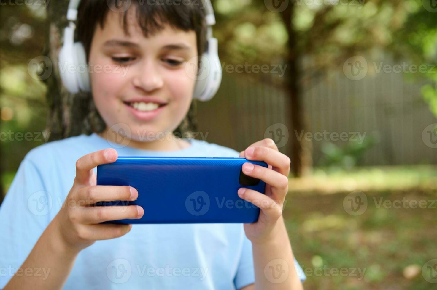 Young boy and girl play games and listen to music on their mobile phones  7468482 Stock Photo at Vecteezy