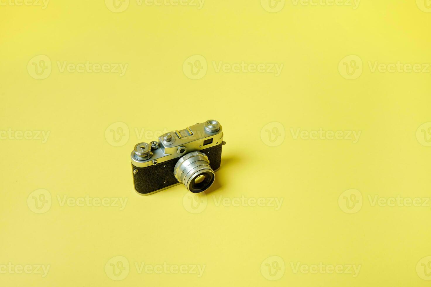 Top view of an old model manual film camera isolated on a yellow background. Flat lay. Copy space photo