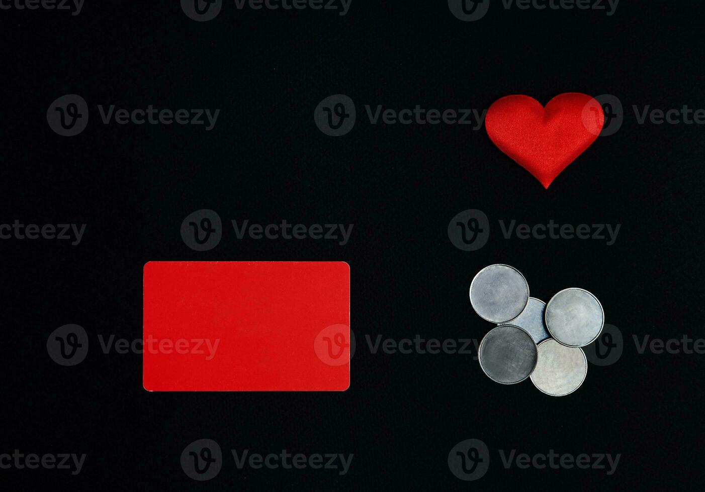 A horizontal red rectangle, red heart and money coins on a black backgroundSt. Valentines Day concept. Border, copy space, top view, celebration, holiday photo