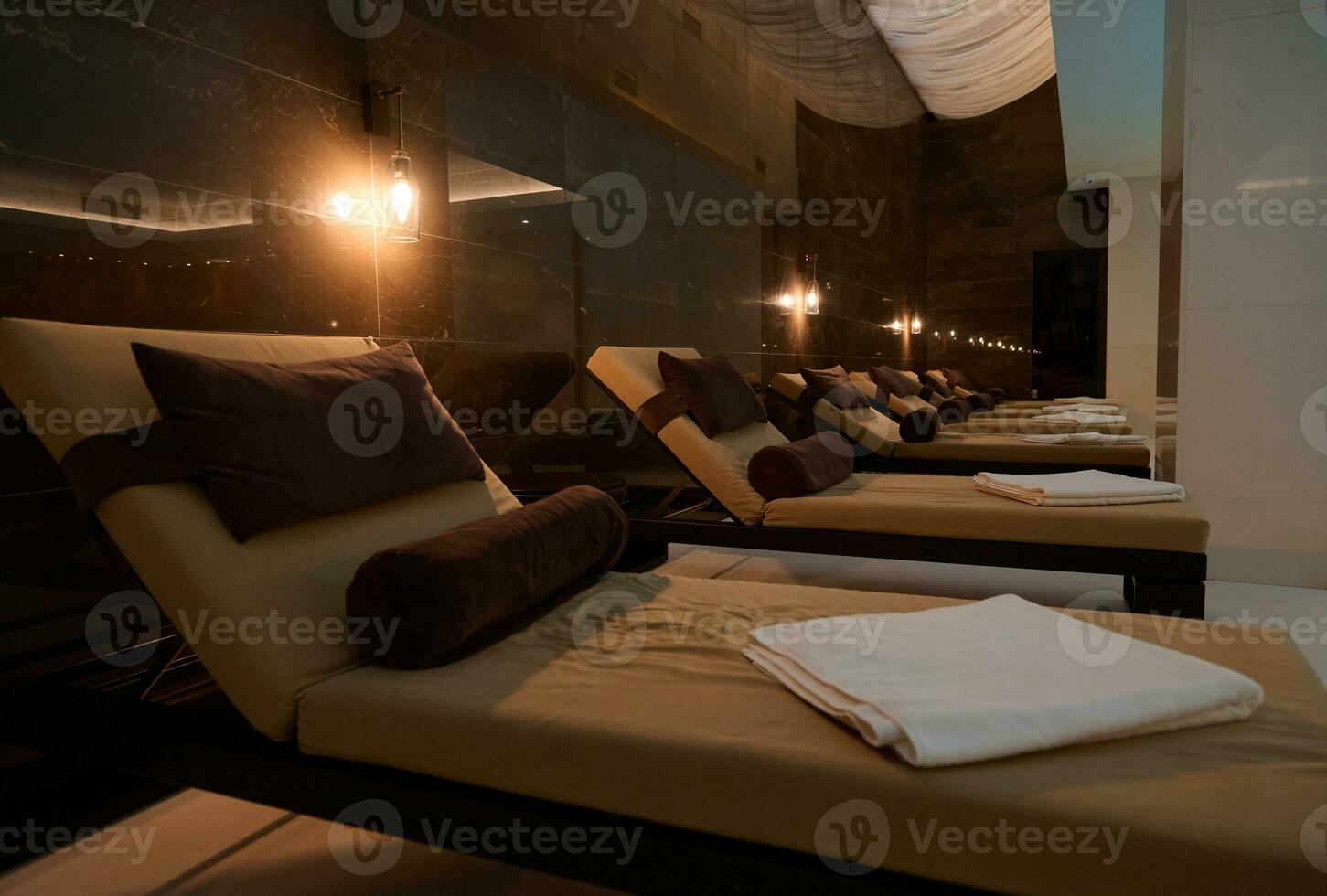 View of loungers in spa room with swimming pool in hotel and wellness spa resort photo