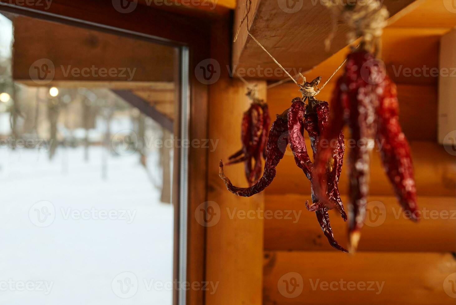 seco rojo chile pimienta colgando desde un cuerda en un de madera pared foto