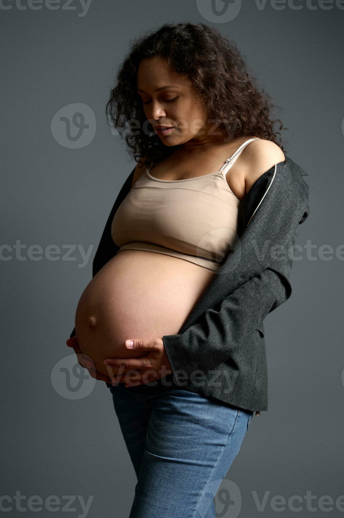 Attractive pregnant woman gently stroking her big belly, experiencing  wonderful emotions feeling baby moves. Pregnancy 27029634 Stock Photo at  Vecteezy