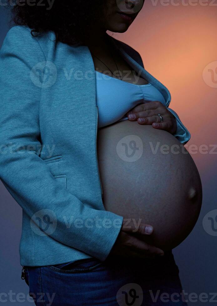 de cerca hermosa embarazada barriga de un mujer expectante madre, acariciando su barriguita, aislado terminado neón ligero antecedentes foto