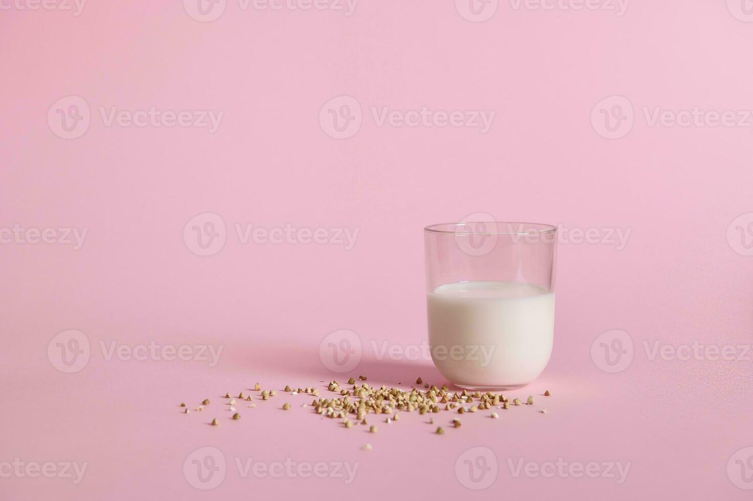 crudo alforfón semillas y vaso con Leche en rosado antecedentes foto