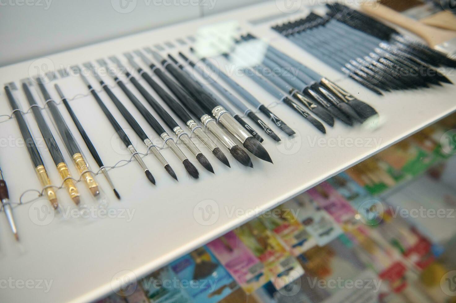 Assortment of paintbrushes and painting tools displayed for sale in school stationery shop. Hobby, leisure, still life photo