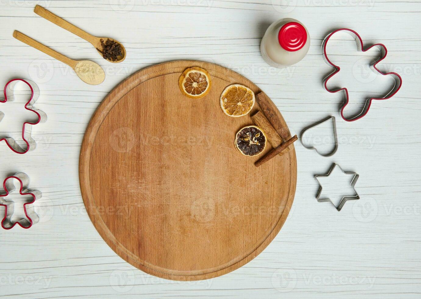 Flat lay. Wooden board with dried orange slices, cinnamon sticks and molds for cutting dough in the form of man, star and heart for cooking gingerbread Christmas cookies photo