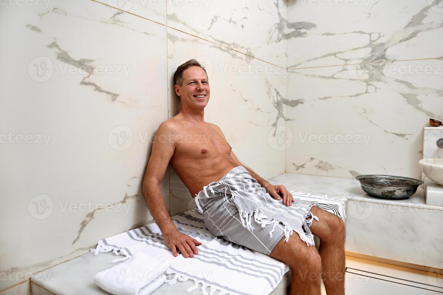 Handsome mature 50 years old European man wrapped in a towel 