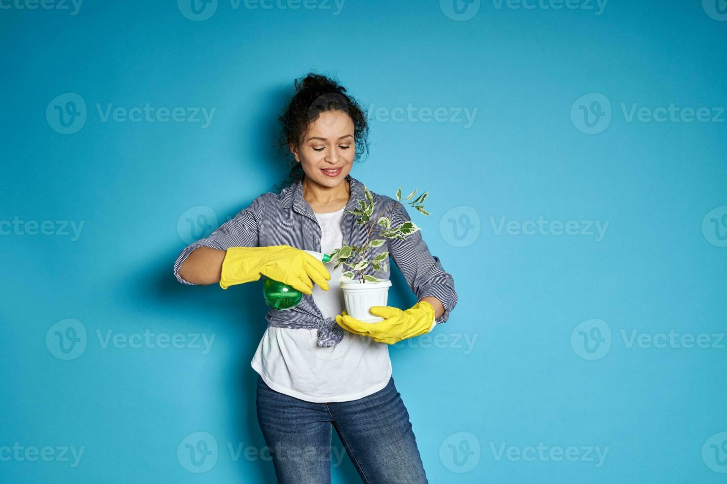 mujer jardinero riego un trasplantado pequeño árbol. ama de casa tomando cuidado de hogar plantas foto