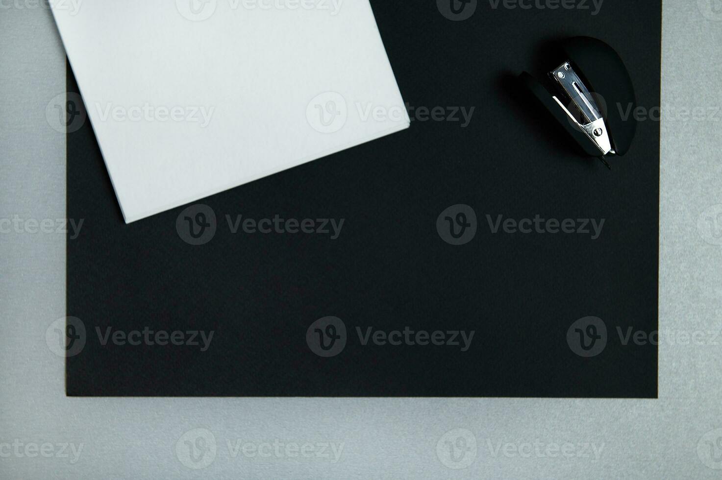 plano laico con bosquejo libro, engrapadora yb negro sábana de papel en un gris antecedentes. Copiar espacio, parte superior ver foto