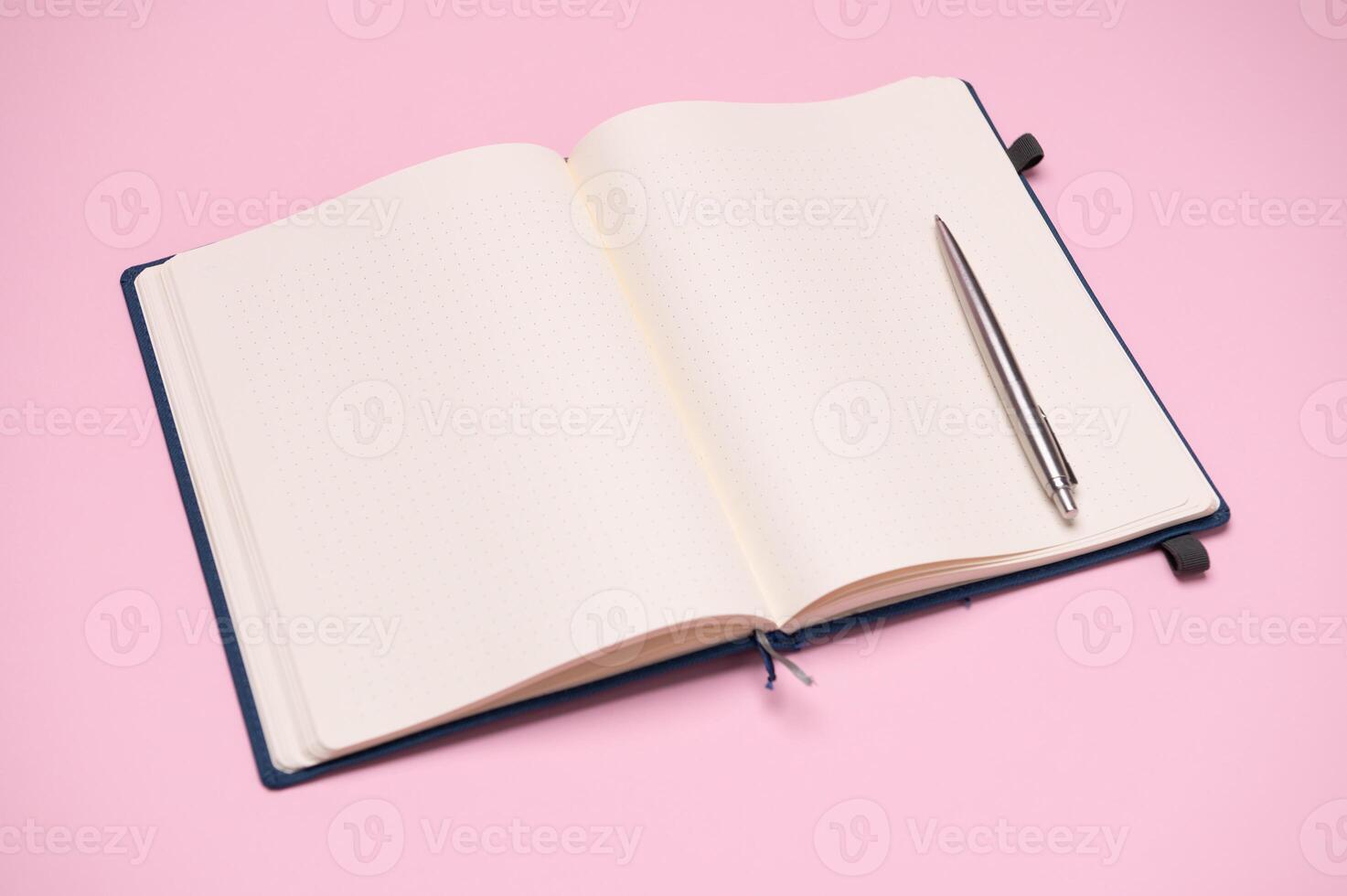 A silver pen on a scratch pad with blank pages for notes and schedules. Business, management and organization concept photo