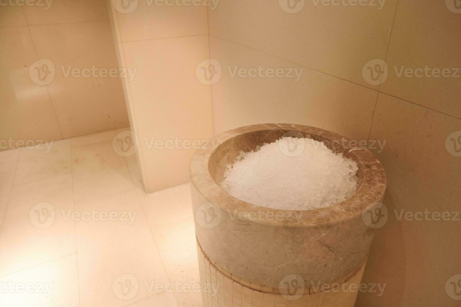 Ice tank in the luxurious hall of the bath and sauna with beige marble walls. Close-up photo