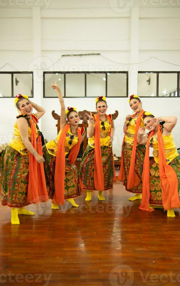 a group of traditional Javanese dancers having fun with their friends on stage after the performance ended photo