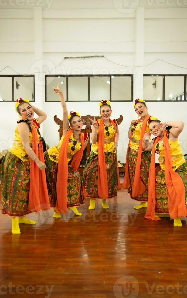 un grupo de tradicional javanés bailarines teniendo divertido con su amigos en etapa después el actuación terminó foto