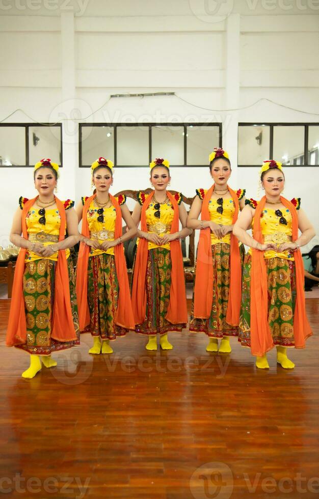 un grupo de tradicional sundanés bailarines en pie con su amigos antes de el actuación empieza foto