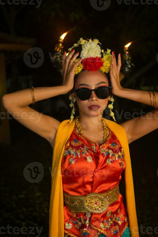 a portrait of an Indonesian dancer with jasmine dangling in her hair adorns her beautiful appearance on stage photo