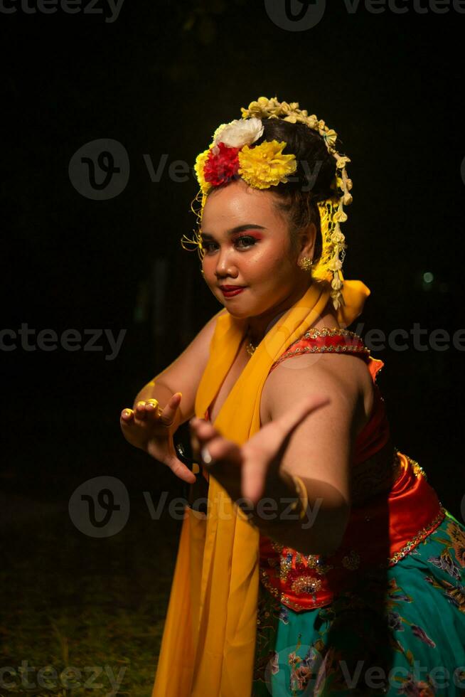 portrait of an Indonesian dancer with a gold belt dancing gracefully photo