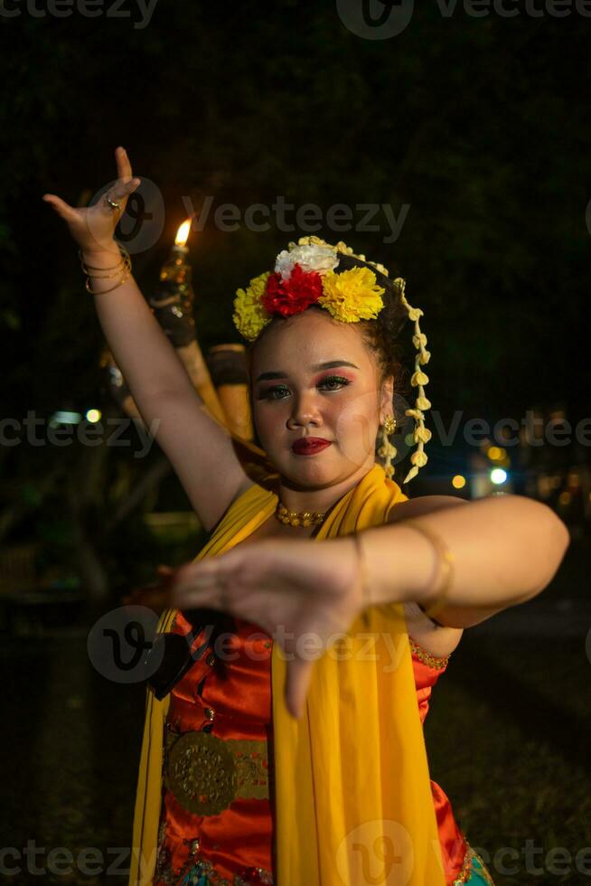 retrato de un indonesio bailarín con un oro cinturón bailando graciosamente foto