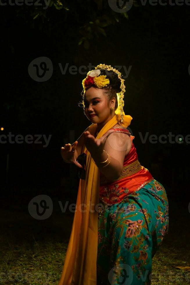 portrait of an Indonesian dancer with a gold belt dancing gracefully photo