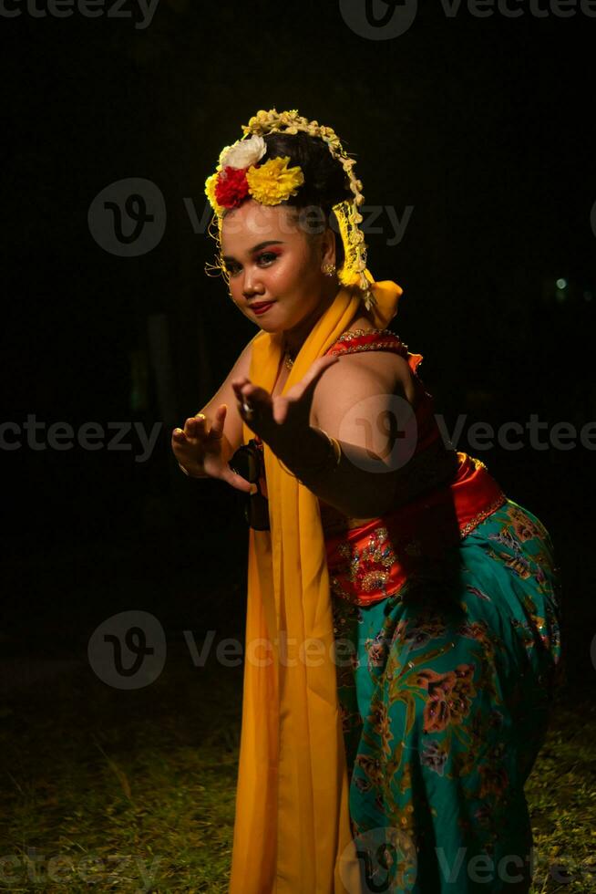 portrait of an Indonesian dancer with a gold belt dancing gracefully photo