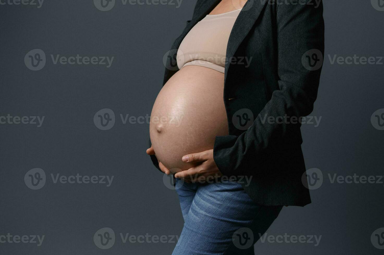 de cerca de hermosa embarazada barriga en el embarazo 36 semana, aislado gris estudio antecedentes. Copiar anuncio espacio. parto foto