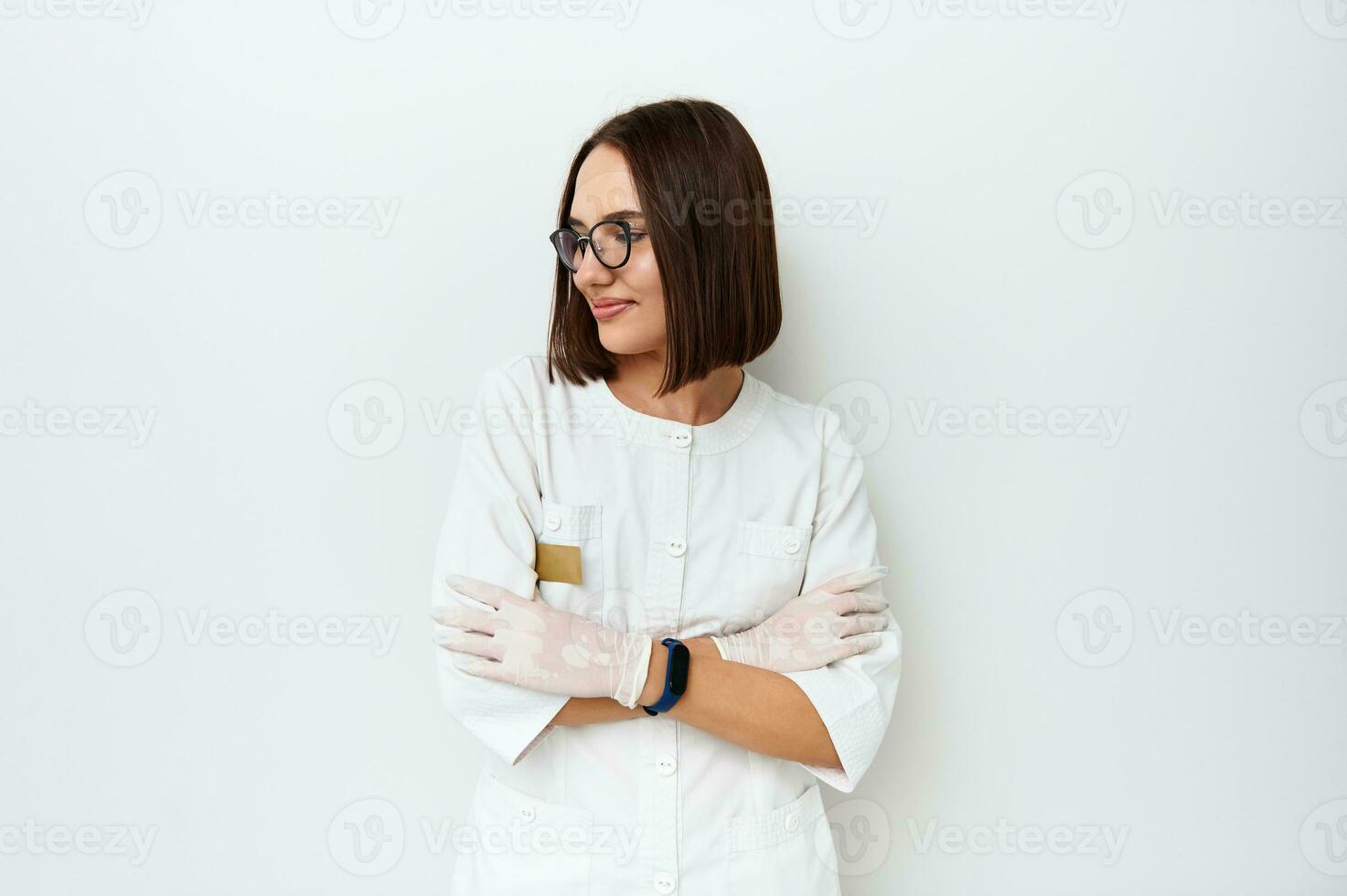 Beautiful doctor looking away while posing on camera over white background with copy space photo