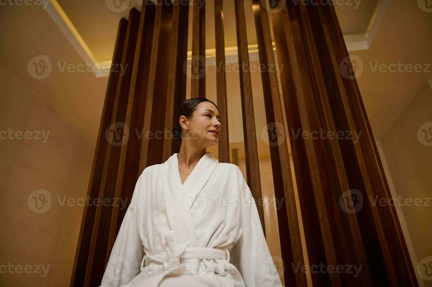 Portrait of a relaxed serene attractive elegant middle aged 30- 40 years old European woman in white terry robe enjoying vacation relaxing at spa resort. Recreation, body care and leisure concept photo