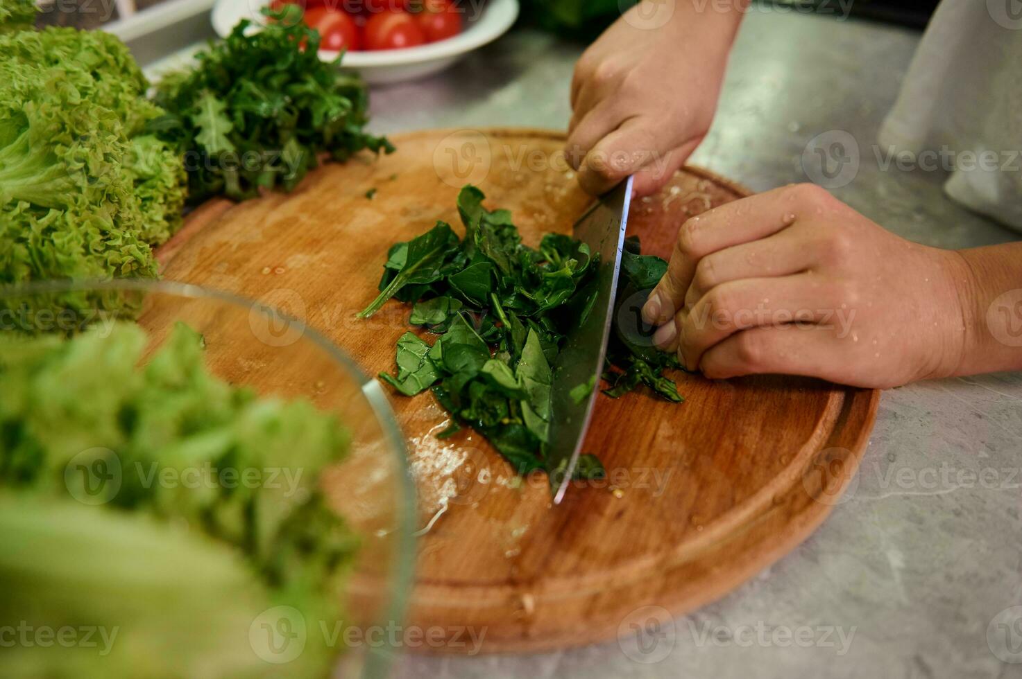 cocinando. comida y concepto de veganismo, vigor y sano comiendo - cerca arriba de hembra mano corte vegetales y Espinacas hojas para ensalada. sano ingredientes para crudo vegano ensalada foto