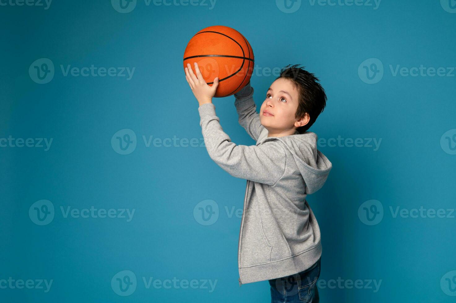 aislado retrato en azul antecedentes de un hermoso chico jugando baloncesto foto