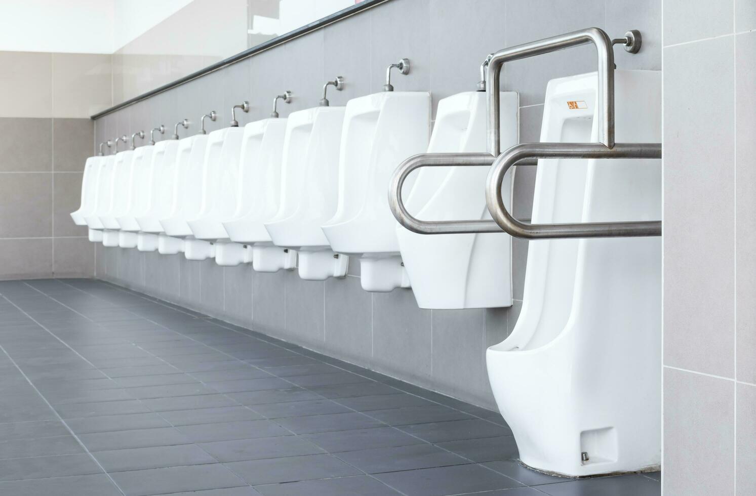 baño de hombres con urinarios de porcelana blanca en línea foto