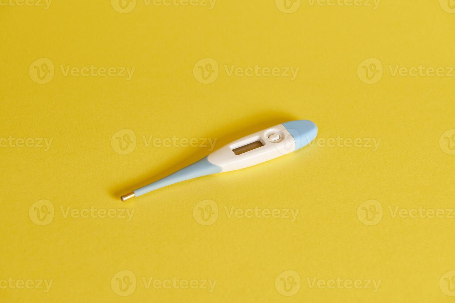 Flat lay composition of a digital Thermometer on yellow background with copy space. Studio shot with soft shadow photo