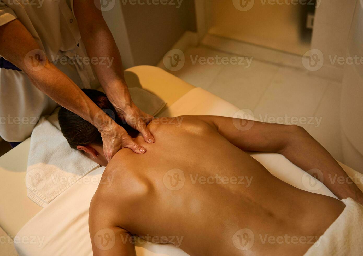 https://static.vecteezy.com/system/resources/previews/027/050/795/non_2x/top-view-of-unrecognizable-professional-masseuse-giving-medical-therapy-massage-to-young-woman-s-back-muscles-relaxing-on-massage-table-at-health-spa-center-ayurvedic-and-alternative-therapy-concept-photo.jpg