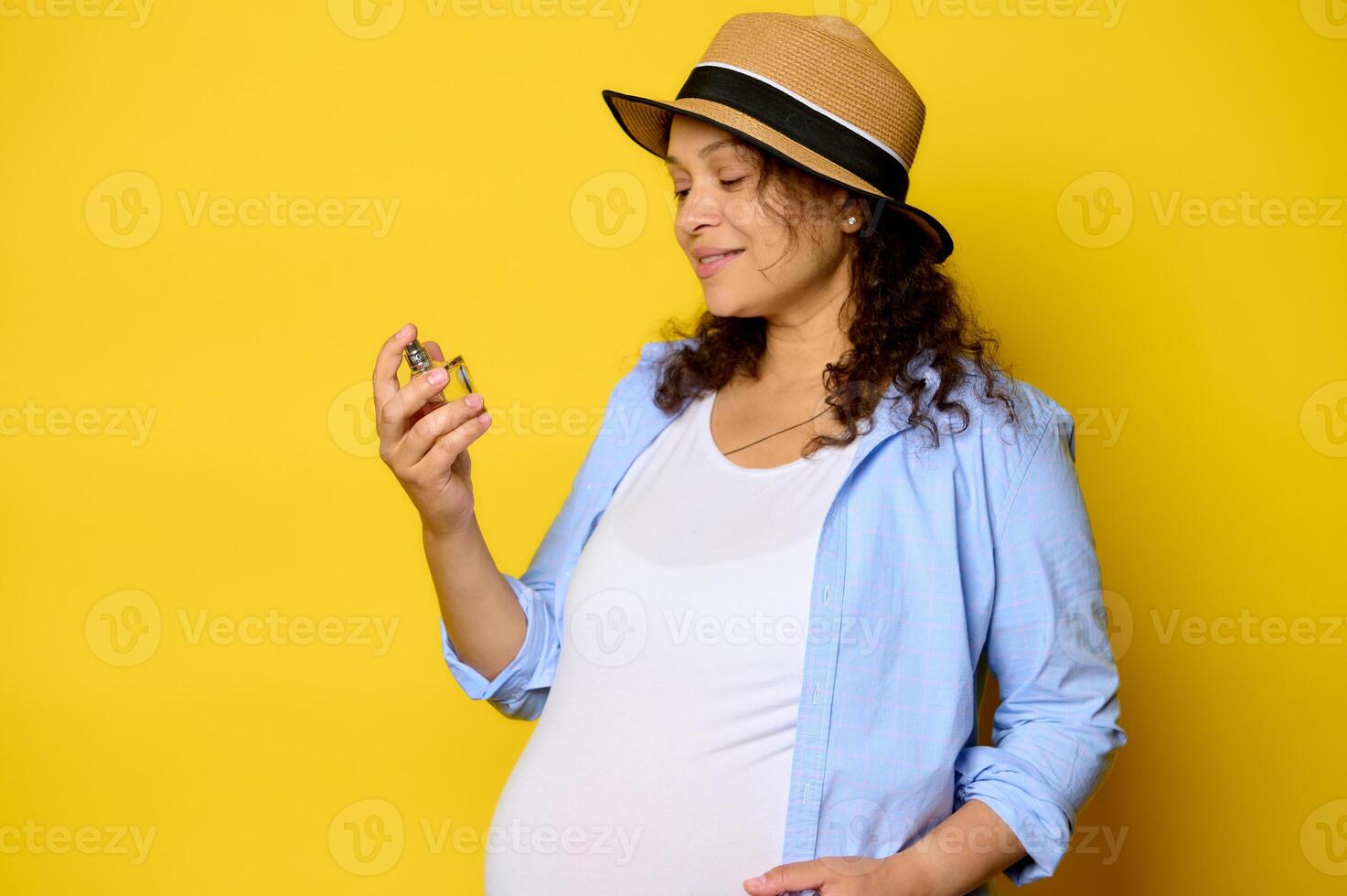 Charming pregnant woman, expectant mother holding a bottle with luxury