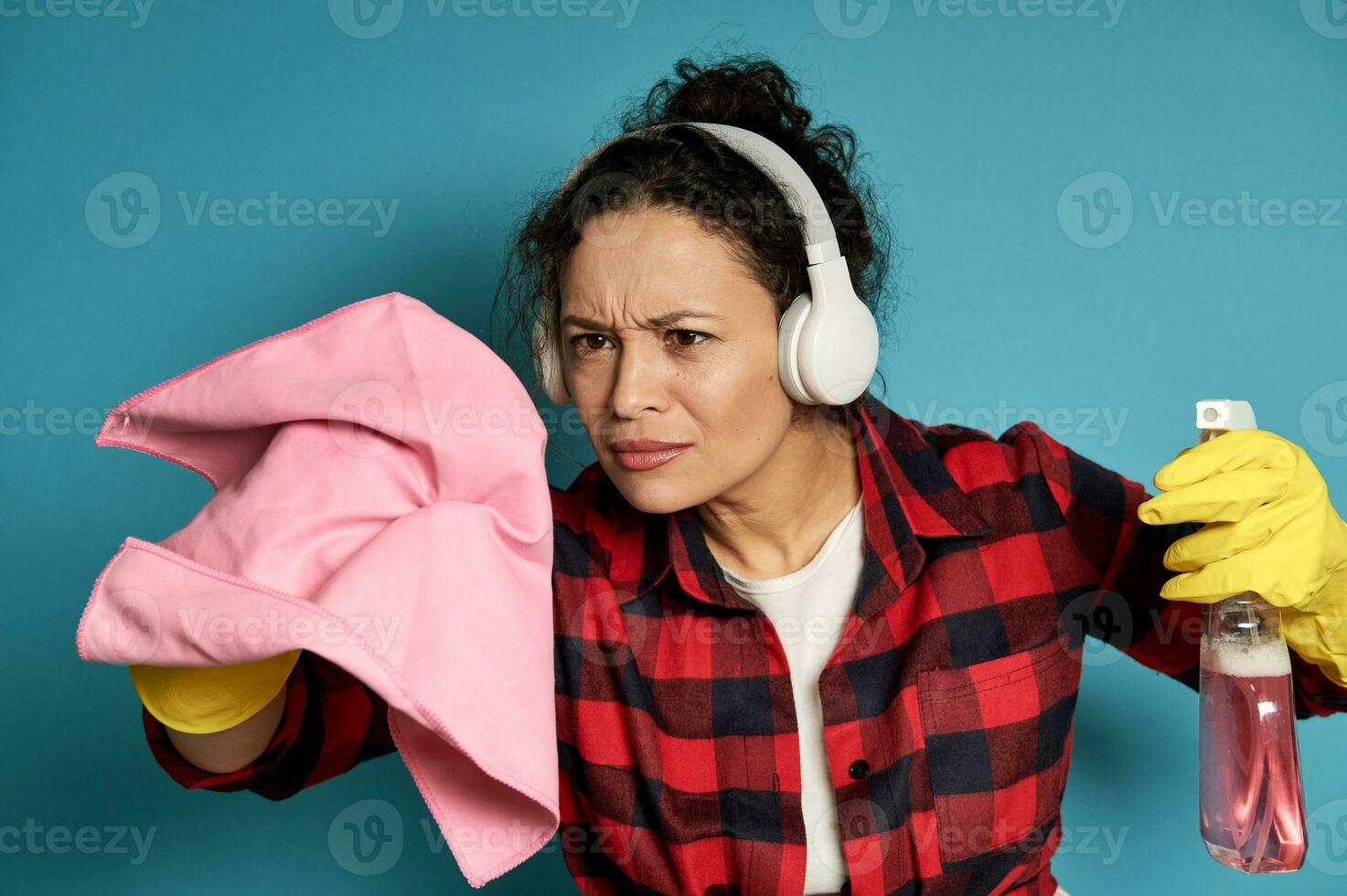 Focused woman simulating cleaning invisible surface with a cleaning rag and a spray with detergent. photo