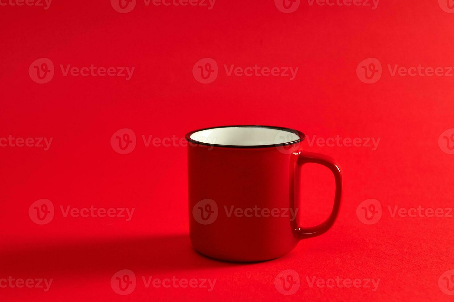 Closeup image of one red mug on red background with soft shadow and copy space for promotion. Red cup. photo