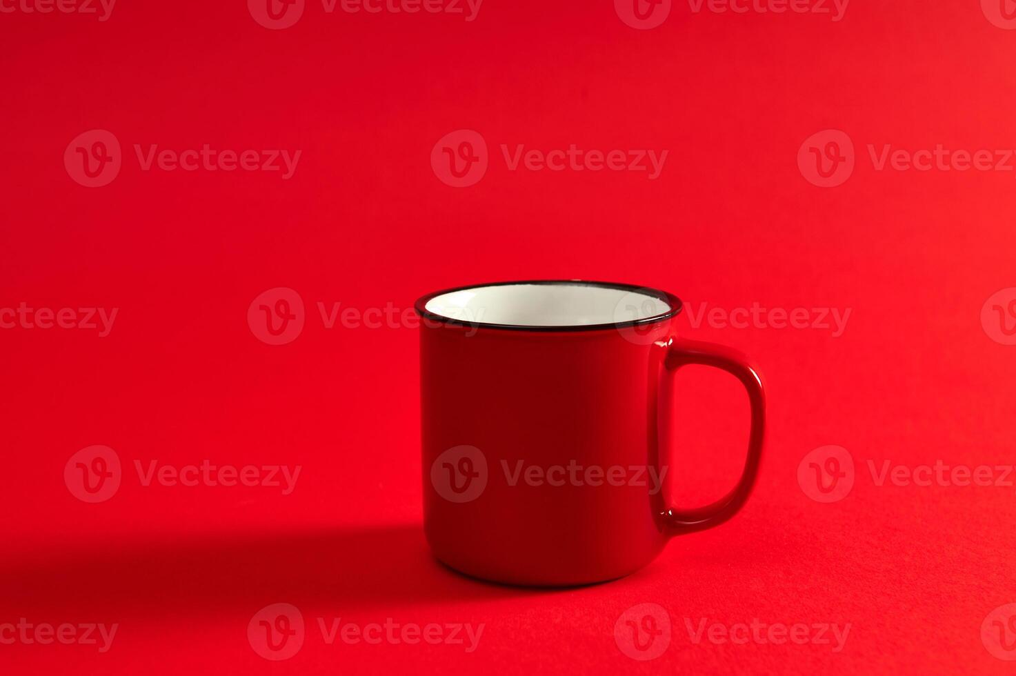 Closeup image of one red mug on red background with soft shadow and copy space for promotion. Red cup. photo