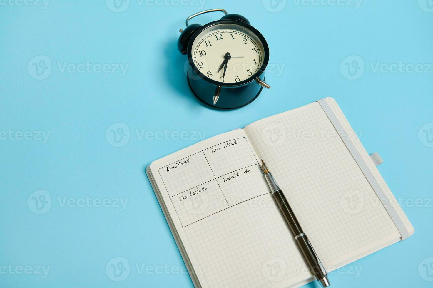 abierto organizador cuaderno con calendario de el día por hora, bolígrafo, alarma reloj en de colores antecedentes con Copiar espacio. hora gestión, fecha límite y concepto de apropiado planificación y organización de hora foto